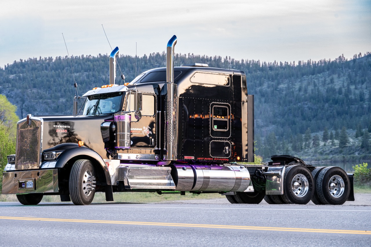 Side profile of the black Running Turtle Kenworth W900 with chrome stacks and purple accent lighting